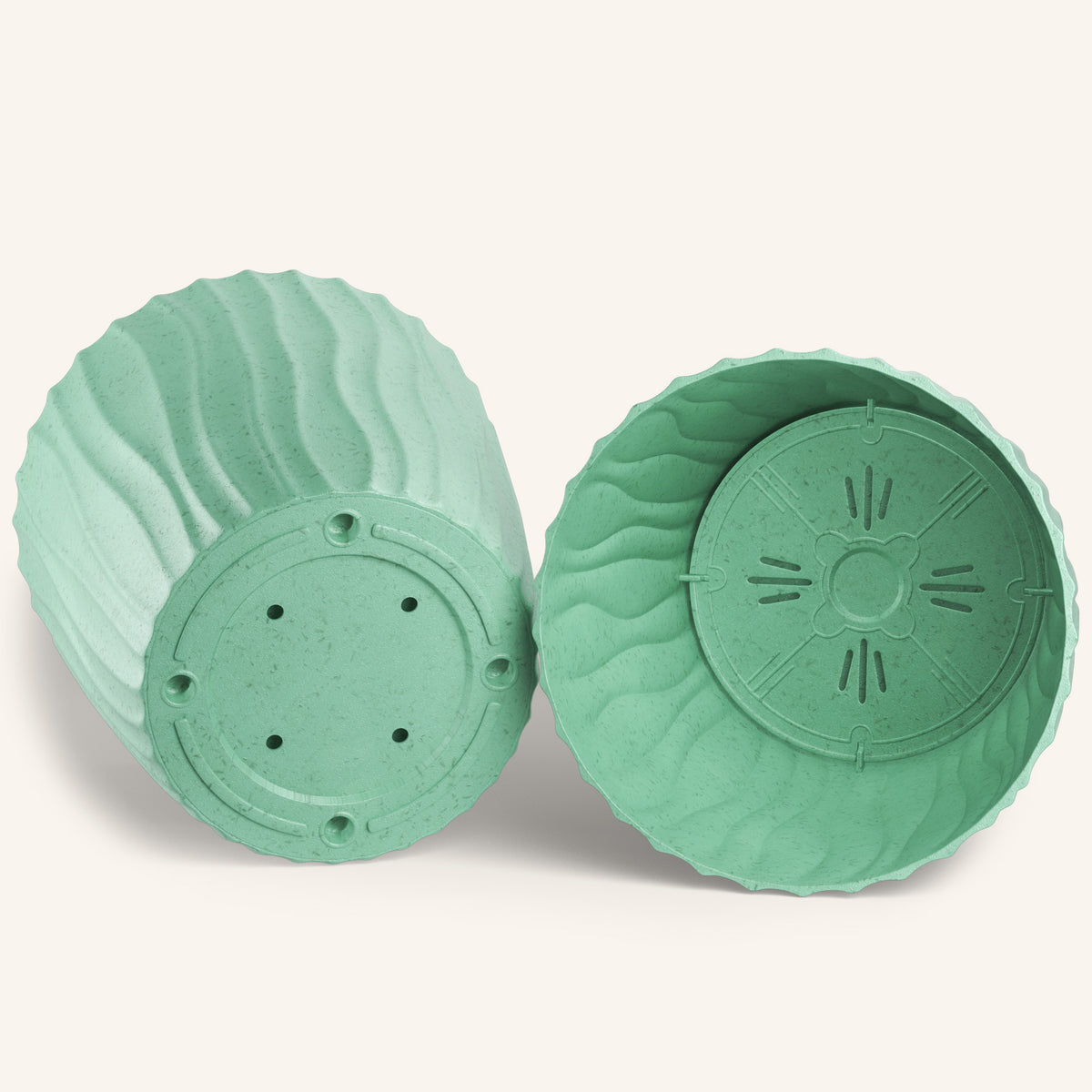 Two ridged green plant pots, one showing drainage holes