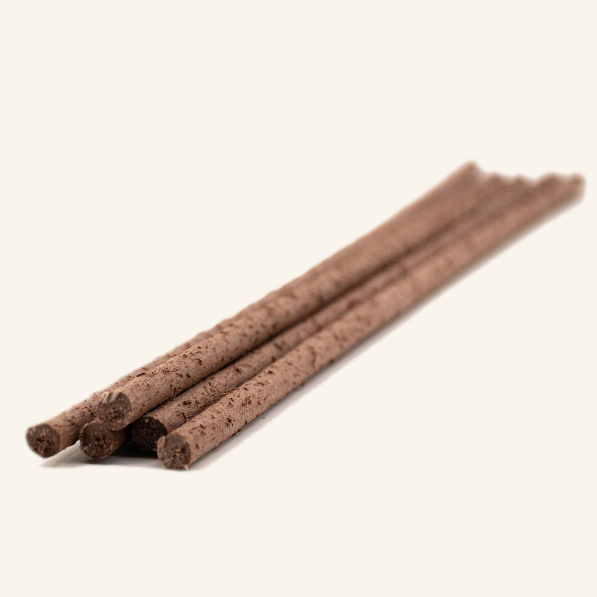 Plusieurs fines tiges en bois brun disposées en diagonale, bâton de soutien biosourcé
