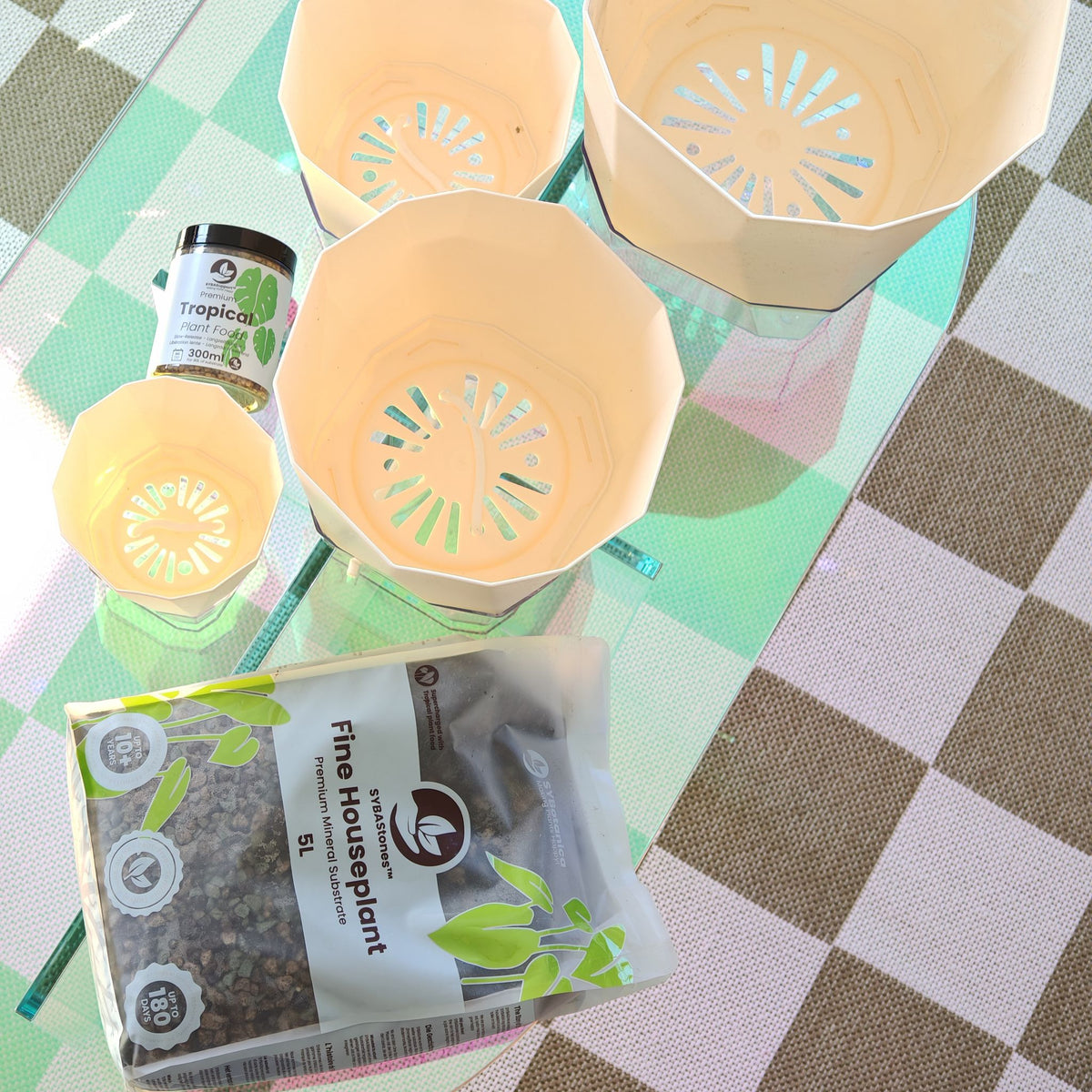 Stablede plastikpotter, glas med plantenæring og pose med mineralsubstrat