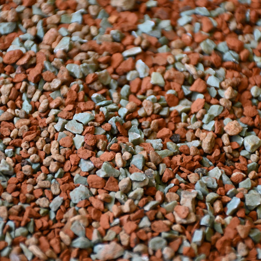 Close-up of mixed terracotta and green mineral gravel granules, orchid mineral mix