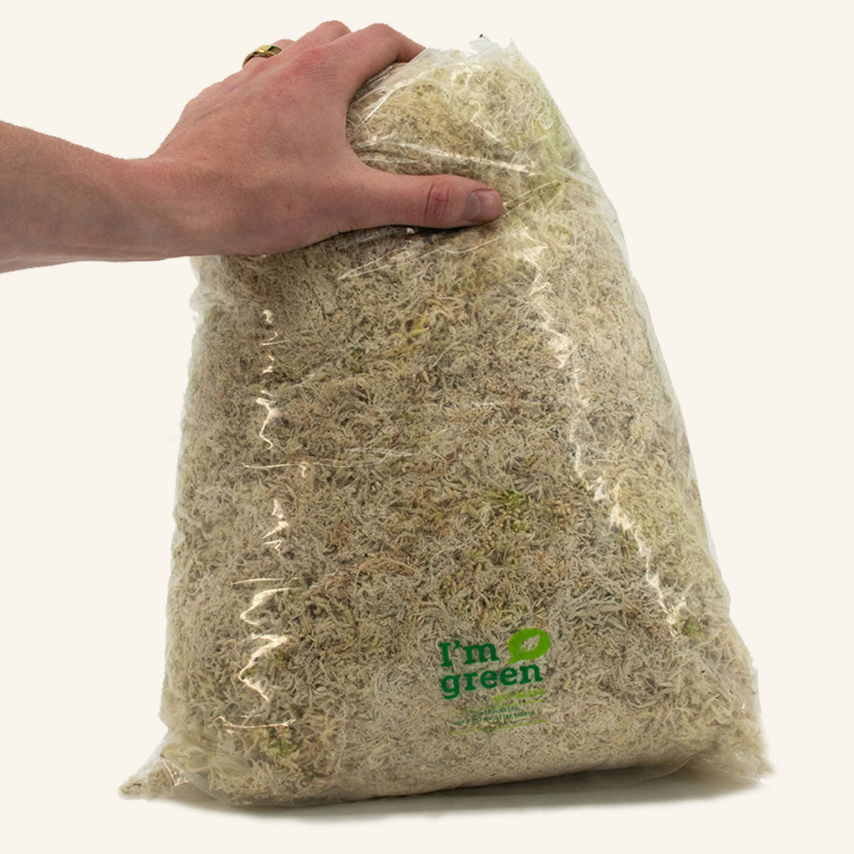 Hand holding bag of dried sphagnum moss, sphaxx
